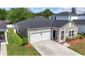 Rear view of home showing neutral siding, well maintained lawn, one car garage, and nicely landscaped entry at 751 Dusty Pine Way, Myrtle Beach, SC 29588