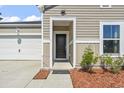 Close up of front entry featuring neutral siding, and nicely landscaped entry way at 751 Dusty Pine Way, Myrtle Beach, SC 29588