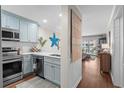Galley kitchen with stainless steel appliances and coastal blue cabinets at 824 N Waccamaw Dr. # 204, Murrells Inlet, SC 29576