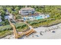 Stunning resort featuring a large pool, beach access, and beautifully designed architecture surrounded by lush greenery at 8323 Cape Dutch Loop, Myrtle Beach, SC 29572