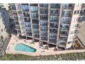 Aerial view of the condo with a swimming pool surrounded by beach chairs and outdoor furniture at 1501 Ocean Blvd. S # 103, North Myrtle Beach, SC 29582