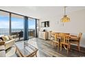 Open-concept living and dining area with ocean views, balcony access, and beach-inspired decor at 1501 Ocean Blvd. S # 103, North Myrtle Beach, SC 29582