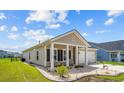 Well-maintained single-story home features a cozy front porch with seating and attached two-car garage at 1664 White Starfish Ct., Calabash, NC 28467