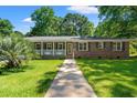 Inviting brick home with a sunny front yard and a welcoming walkway leading to the entrance at 2415 Magnolia Lane, Little River, SC 29566
