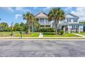 Two-story home featuring a double porch, palm trees, and a well-manicured front yard at 338 St. Julian Ln., Myrtle Beach, SC 29579