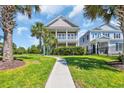 Charming two-story home with a double porch and lush landscaping with palm trees at 338 St. Julian Ln., Myrtle Beach, SC 29579
