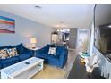 The living room features blue sofas and a view of the dining area at 3401 Dunes St. # A3, North Myrtle Beach, SC 29582