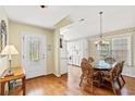 Bright dining area with hardwood floors, glass table and adjacent kitchen provides seamless flow at 4002 Acorn Way, North Myrtle Beach, SC 29582
