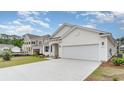 Beautiful home exterior with two-car garage, manicured lawn, and newly constructed home next door at 438 Clear Lake Dr., Conway, SC 29526