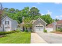 Beautiful home with green front yard and trees providing shade, attached garage, and a welcoming porch at 4406 Barcelona Ln., Little River, SC 29566