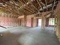 Living room under construction showing wood frames, concrete floor, exposed ceiling, and window placement at 475 Highway 348, Loris, SC 29569