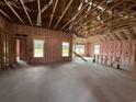 Spacious living room under construction with natural light from three large windows, framed walls, and open ceilings at 475 Highway 348, Loris, SC 29569