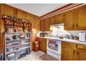 Functional kitchen with wooden cabinets, a white oven range, and open shelving for additional storage at 4810 Circle Dr., Loris, SC 29569