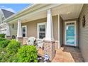 Inviting front porch with comfortable seating, brick accents, and a secure KTC security system sign at 505 Joy Way Ct., Longs, SC 29568