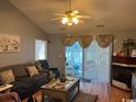 Cozy living room with sliding glass doors to a screened porch and a decorative fireplace at 550 Bridgeport Dr., Myrtle Beach, SC 29577