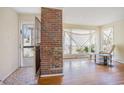 Cozy living room featuring hardwood floors, brick column, and bright natural light at 5612 N Kings Hwy., Myrtle Beach, SC 29577