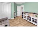 Well-organized living room with hardwood floors, a white shelving unit, and a cozy gray sofa at 732 American Beech St., Loris, SC 29569