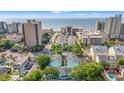 Aerial view of a beachfront property with easy access to the beach and ocean, surrounded by mature trees at 7403 N Ocean Blvd. # C, Myrtle Beach, SC 29572
