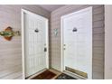 Condo building entrance with two white doors, seahorse and fish decorations, and welcome mats at 802 Colony Pl. # 2E, Calabash, NC 28468