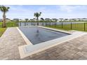Backyard pool with a safety cover, paver patio, palm trees and a picturesque view of the lake at 863 Agostino Dr., Myrtle Beach, SC 29579