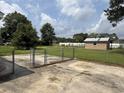 Spacious backyard featuring a chain-link fence, a concrete patio, and a brick storage shed at 1002 S Beech Ave., Andrews, SC 29510