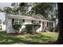 Charming white brick home with black shutters, a red front door, new landscaping, and a well manicured front yard at 1014 Bay Dr., Surfside Beach, SC 29575