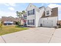 Traditional two-story home showcases a lovely yard, attached garage, and cozy front porch with patriotic decor at 104 Clovis Circle, Myrtle Beach, SC 29579