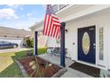 Inviting front porch with seating, garden beds, and a charming door that adds a welcoming touch to the home at 104 Clovis Circle, Myrtle Beach, SC 29579