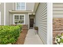 Inviting front porch with stone accents, lush greenery, and decorative flower baskets at 115 Machrie Loop # D, Myrtle Beach, SC 29588