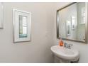 Clean, well-lit half-bathroom with a white pedestal sink, framed mirrors, and neutral decor at 1403 Nokota Dr., Conway, SC 29526