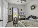 Bright bedroom featuring a cozy chair, ceiling fan, and view from the window at 191 Marley Blue Dr., Little River, SC 29566