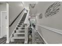 Inviting foyer with staircase, neutral paint, decorative accents, and wood-look flooring at 191 Marley Blue Dr., Little River, SC 29566