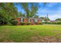 A well-manicured front lawn and classic brick home with black shutters add charm at 203 Longwood Ln., Conway, SC 29527