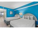Bright bedroom featuring two beds, blue walls, and a balcony at 2207 S Ocean Blvd. # 1517, Myrtle Beach, SC 29577