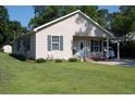 A charming home featuring a carport, lush lawn, and pleasing curb appeal at 304 S Magnolia Ave., Andrews, SC 29510