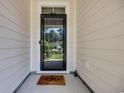 View of the home's entryway, featuring a black screen door and a welcoming 'Aloha' doormat at 340 Scottsdale Ct., Murrells Inlet, SC 29576