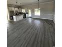 Spacious living room with gray flooring, bright windows, and open concept with kitchen area at 3444 Asbury Rd., Aynor, SC 29511