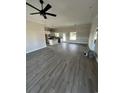 Open concept living room featuring new gray floors, modern ceiling fan, and kitchen in the background at 3444 Asbury Rd., Aynor, SC 29511