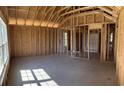 Unfinished home interior featuring wood framing, concrete floors, and ample natural light from the window at 3530 Good Luck Rd., Aynor, SC 29511