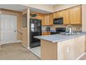 Well-equipped kitchen showcasing ample wood cabinetry and modern black appliances, ideal for cooking and entertaining at 4574 Girvan Dr. # D, Myrtle Beach, SC 29579