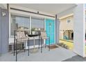 Cozy porch with seating, a table, and a charming blue door at 5409 North Ocean Blvd. # 106/7108, North Myrtle Beach, SC 29582