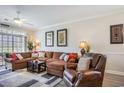 Comfortable living room featuring a large sectional sofa, leather recliner, ceiling fan, and natural light from a large window at 5751 Oyster Catcher Dr. # 315, North Myrtle Beach, SC 29582