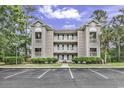 Three-story condo complex, ample parking, and mature trees create an inviting, peaceful setting at 598 Blue Stem Dr. # 52E, Pawleys Island, SC 29585