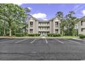 Three-story condo complex, ample parking, and mature trees create an inviting, peaceful setting at 598 Blue Stem Dr. # 52E, Pawleys Island, SC 29585