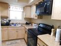 Functional kitchen featuring light wood cabinets, laminate counters, and modern black appliances for easy meal preparation at 6805 Creekwatch Rd. # 105, Myrtle Beach, SC 29588