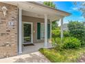 Inviting covered porch entrance with brick accents and manicured landscaping at 751 Painted Bunting Dr. # E, Murrells Inlet, SC 29576