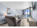 Bright living room featuring comfortable seating, decor, and sliding glass doors to the balcony at 9550 Shore Dr. # 529, Myrtle Beach, SC 29572