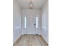 Bright foyer with a modern chandelier, white trim, and wood-look flooring create an inviting entrance at 1079 Laconic Dr., Myrtle Beach, SC 29588