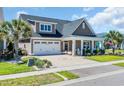 Well-maintained home featuring an attached garage, landscaped yard, and a welcoming front porch with rocking chairs at 1145 Captain Hooks Way, North Myrtle Beach, SC 29582