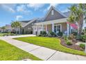 Charming home with a well-manicured lawn, landscaping, and covered front porch with white columns at 1145 Captain Hooks Way, North Myrtle Beach, SC 29582